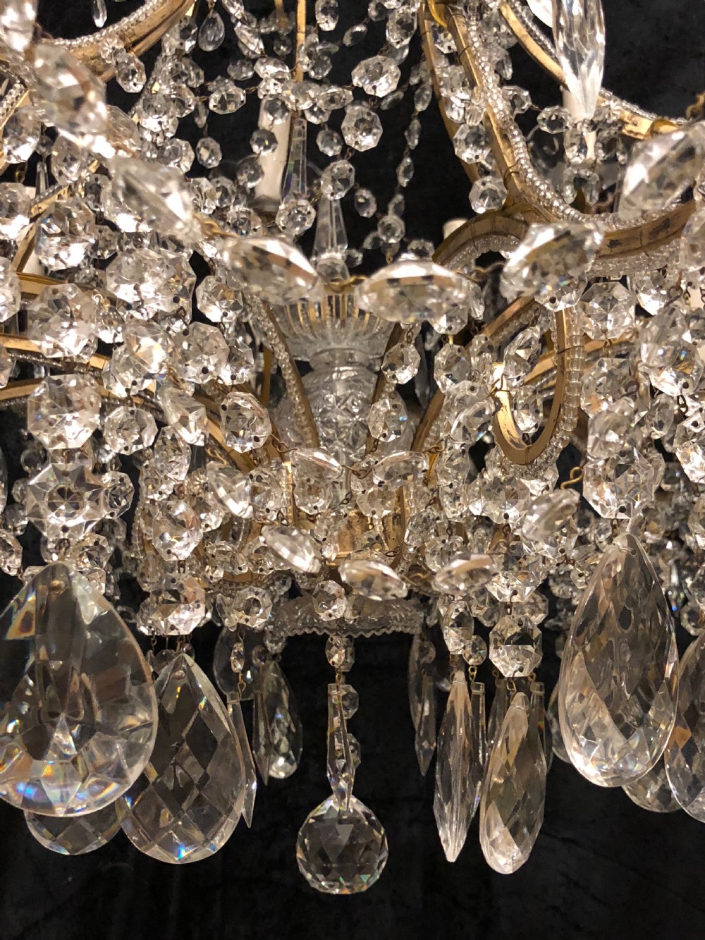 A large Italian Florentine eighteen light chandelier featuring a gilt scroll frame hung with cut crystal drops and glass bead strands. View IX