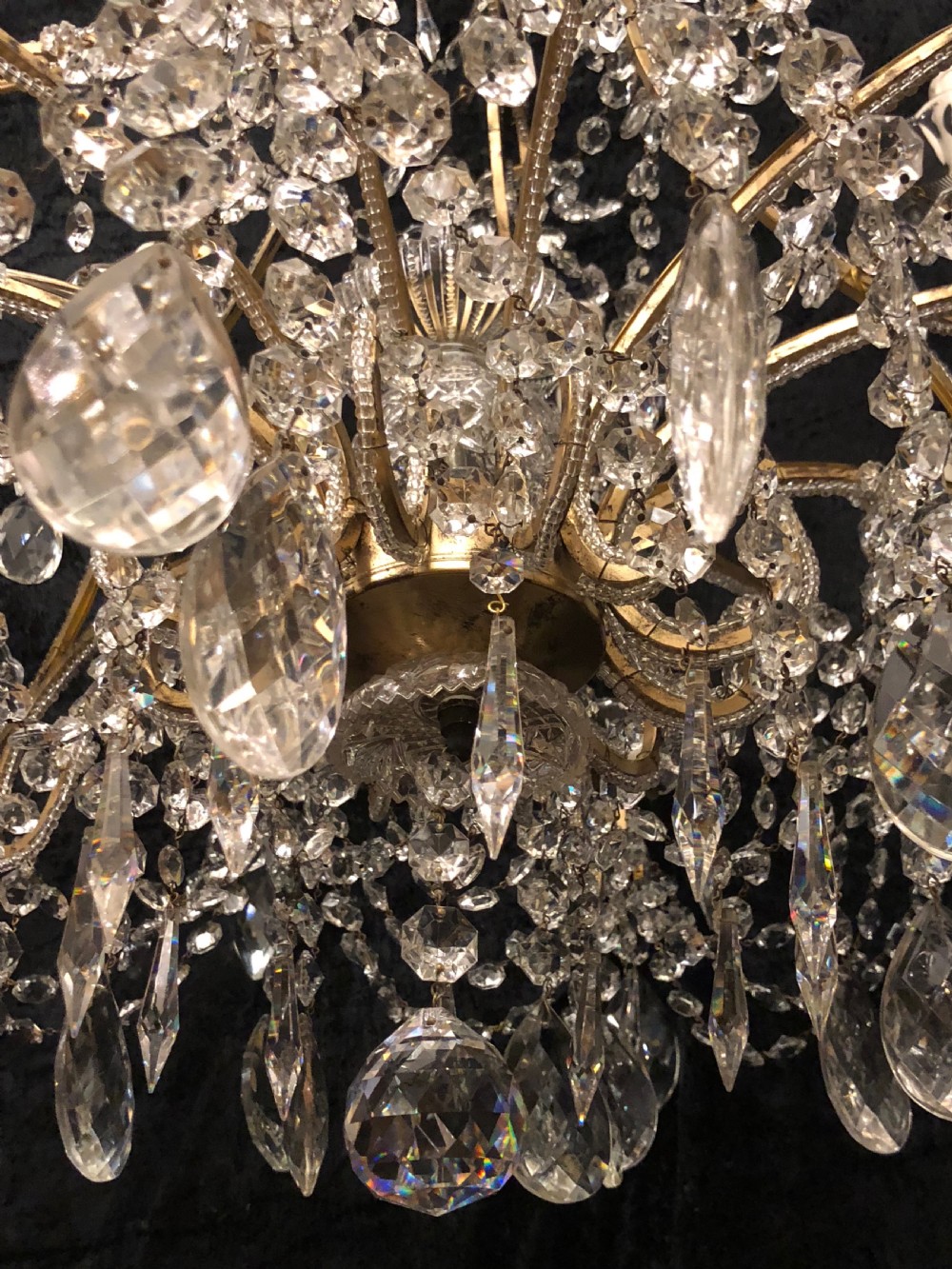 A large Italian Florentine eighteen light chandelier featuring a gilt scroll frame hung with cut crystal drops and glass bead strands. View XI