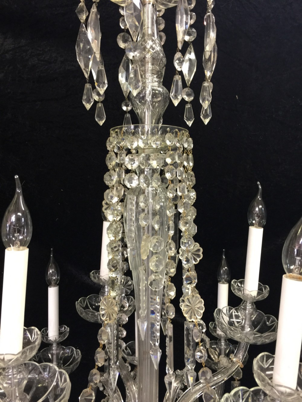 A multi-armed antique cut glass chandelier featuring cascading crystal drops, scalloped bobeches, and white candle sleeves. View III