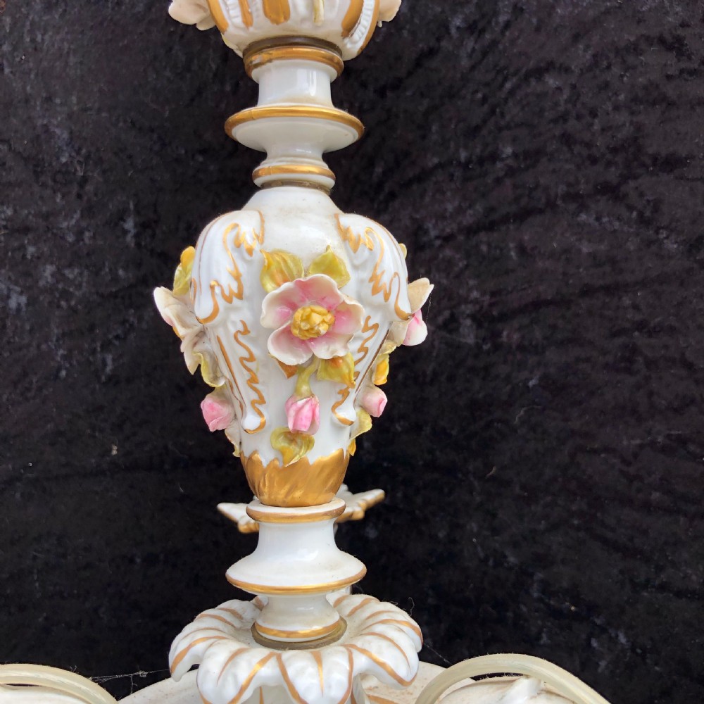 A three-arm Capodimonte porcelain chandelier with white glaze, gold scroll detailing, applied ceramic flowers, and candle-style bulb holders. View IV
