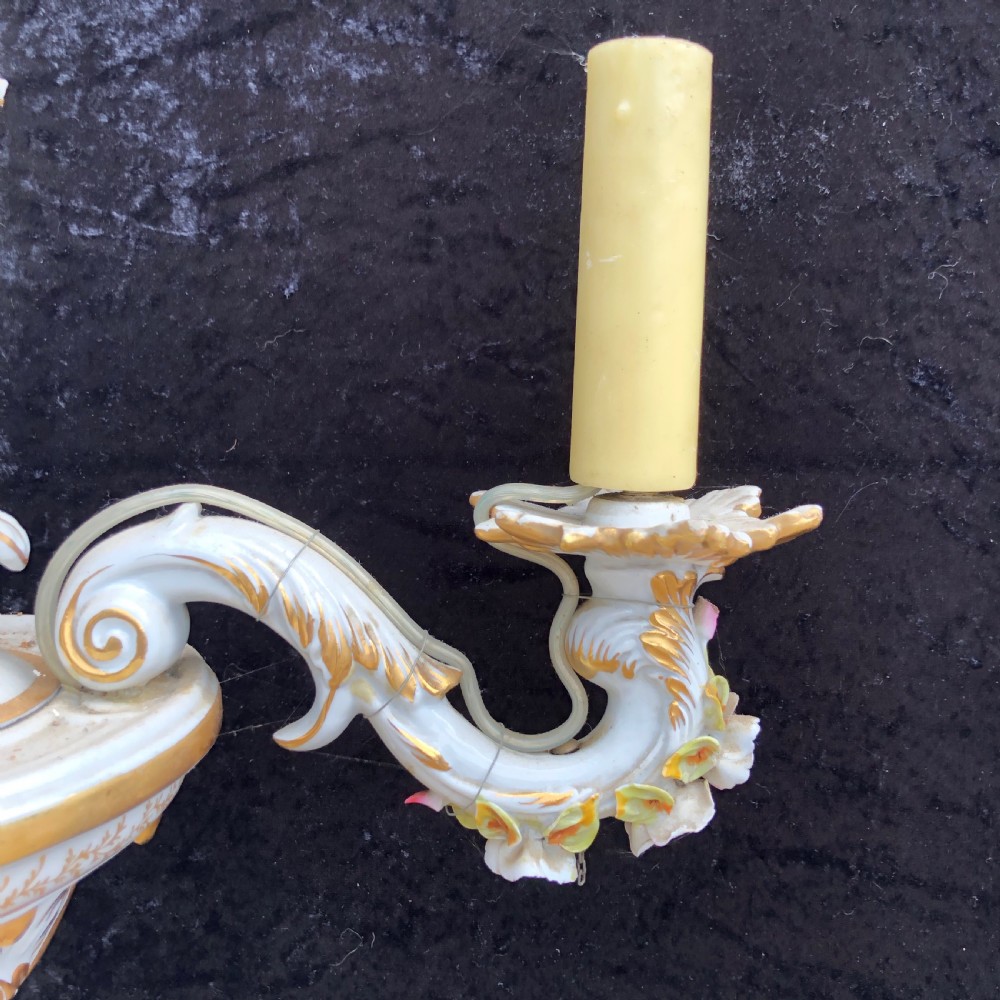 A three-arm Capodimonte porcelain chandelier with white glaze, gold scroll detailing, applied ceramic flowers, and candle-style bulb holders. View VI