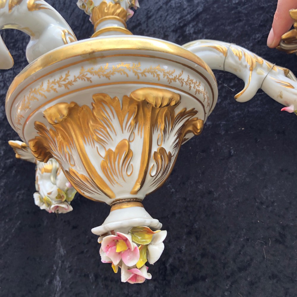 A three-arm Capodimonte porcelain chandelier with white glaze, gold scroll detailing, applied ceramic flowers, and candle-style bulb holders. View VIII