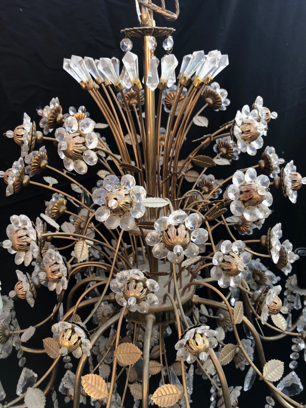 A twelve-light Florentine chandelier crafted from gilt metal featuring crystal flower heads, leaf details, and faceted crystal drops hanging from curved arms. View II