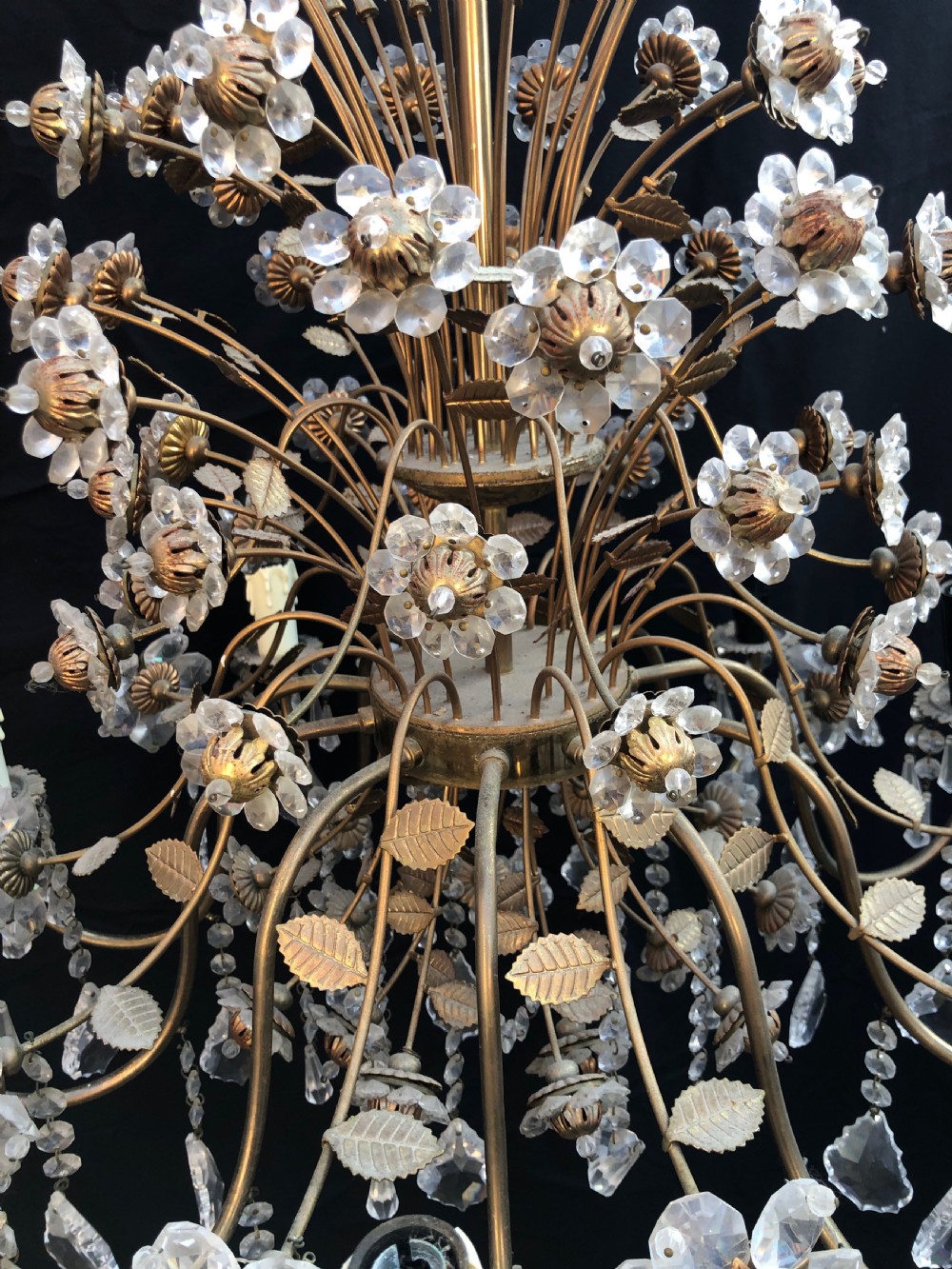 A twelve-light Florentine chandelier crafted from gilt metal featuring crystal flower heads, leaf details, and faceted crystal drops hanging from curved arms. View III