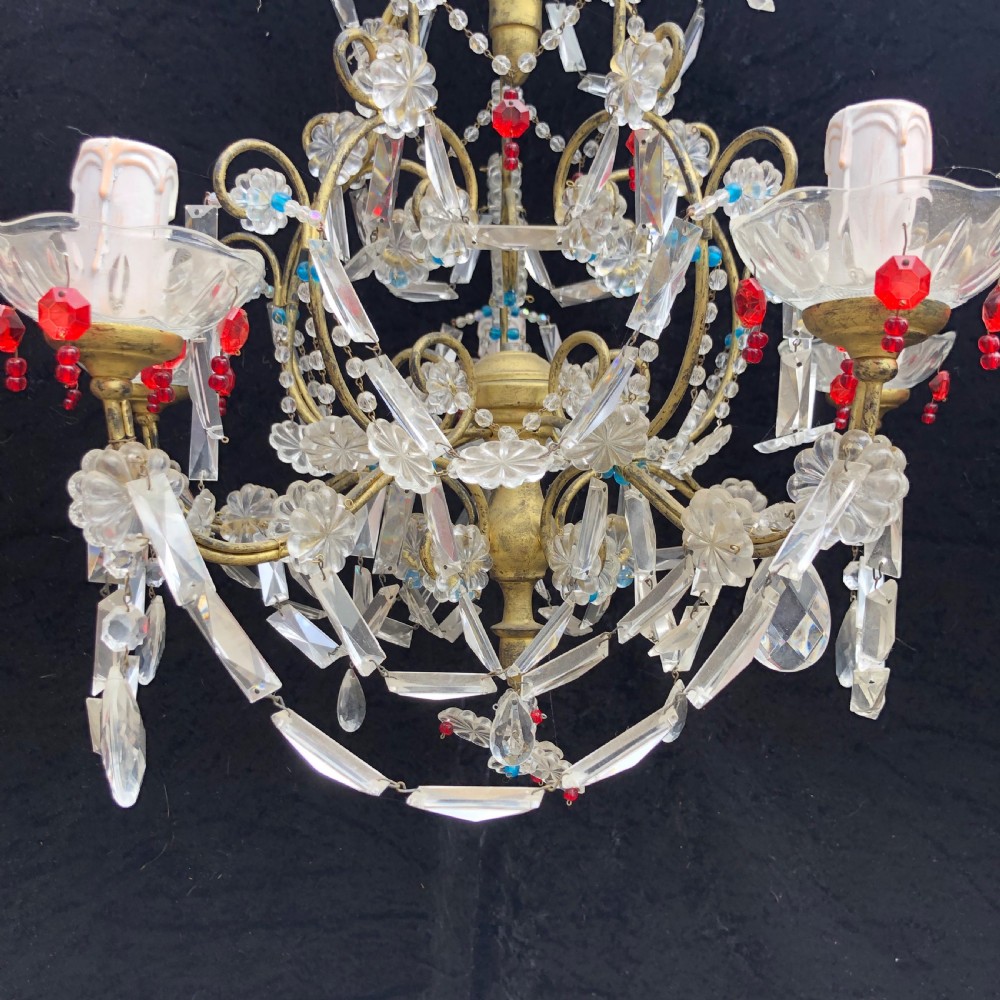 A five-light Florentine chandelier featuring a gilt metal frame adorned with clear crystal drops, floral glass rosettes, and coloured accent beads. View V