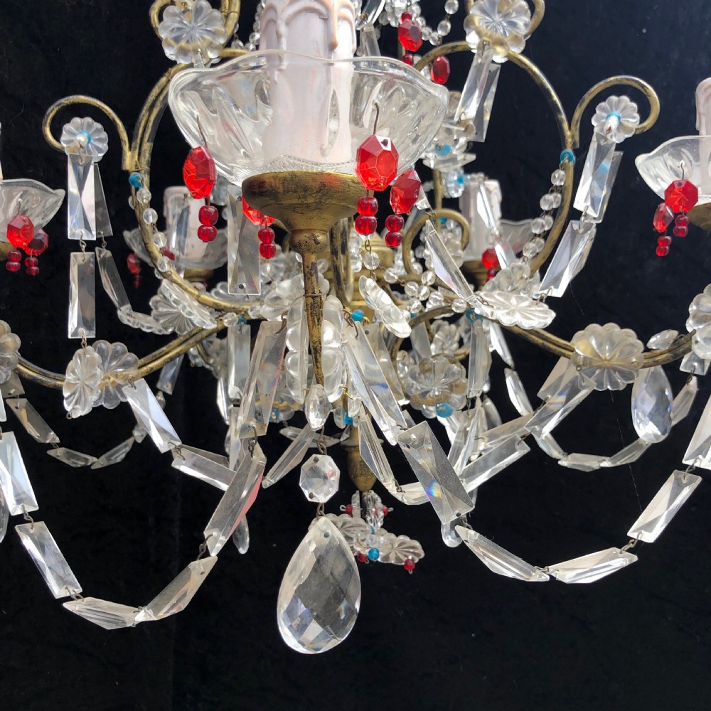 A five-light Florentine chandelier featuring a gilt metal frame adorned with clear crystal drops, floral glass rosettes, and coloured accent beads. View VII
