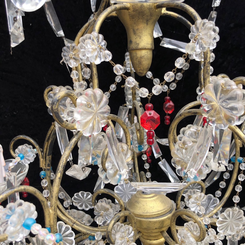 A five-light Florentine chandelier featuring a gilt metal frame adorned with clear crystal drops, floral glass rosettes, and coloured accent beads. View VIII