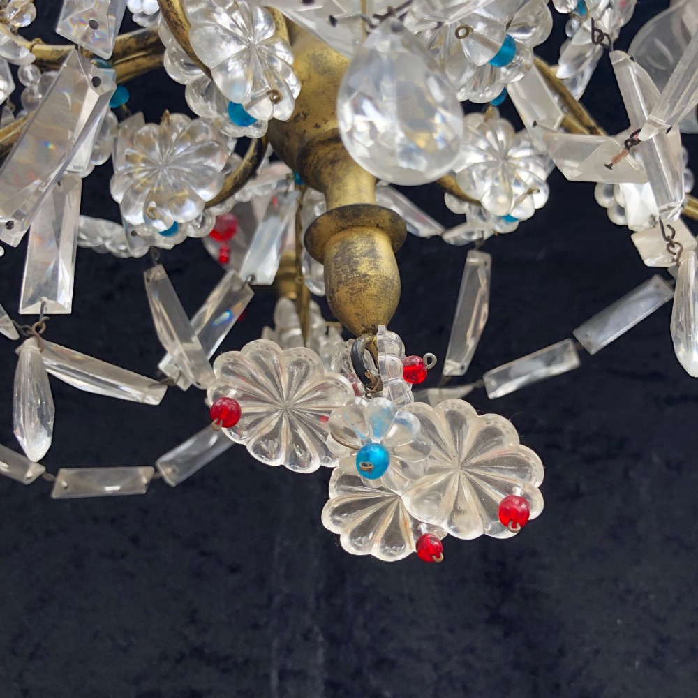 A five-light Florentine chandelier featuring a gilt metal frame adorned with clear crystal drops, floral glass rosettes, and coloured accent beads. View IX