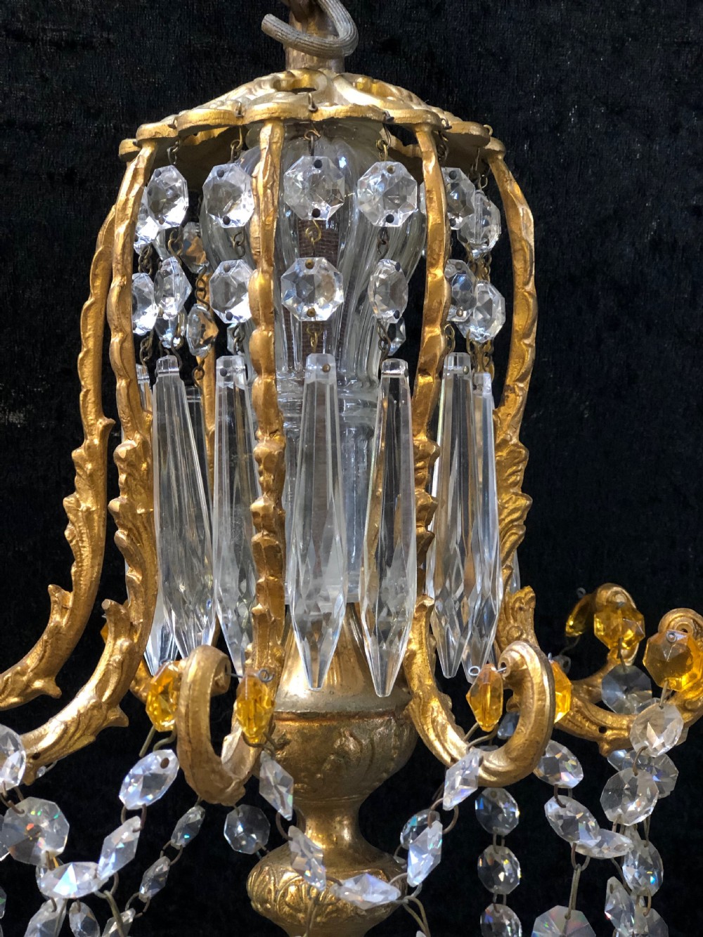 An Italian gilt-brass chandelier featuring multiple scrolling arms draped with crystal-beaded pod shades and amber glass drops. View III