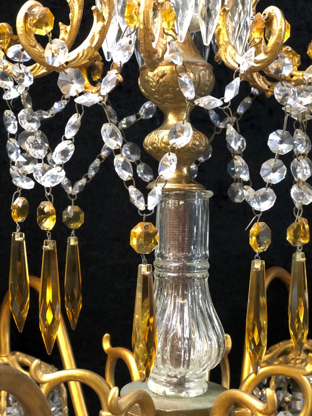 An Italian gilt-brass chandelier featuring multiple scrolling arms draped with crystal-beaded pod shades and amber glass drops. View IV