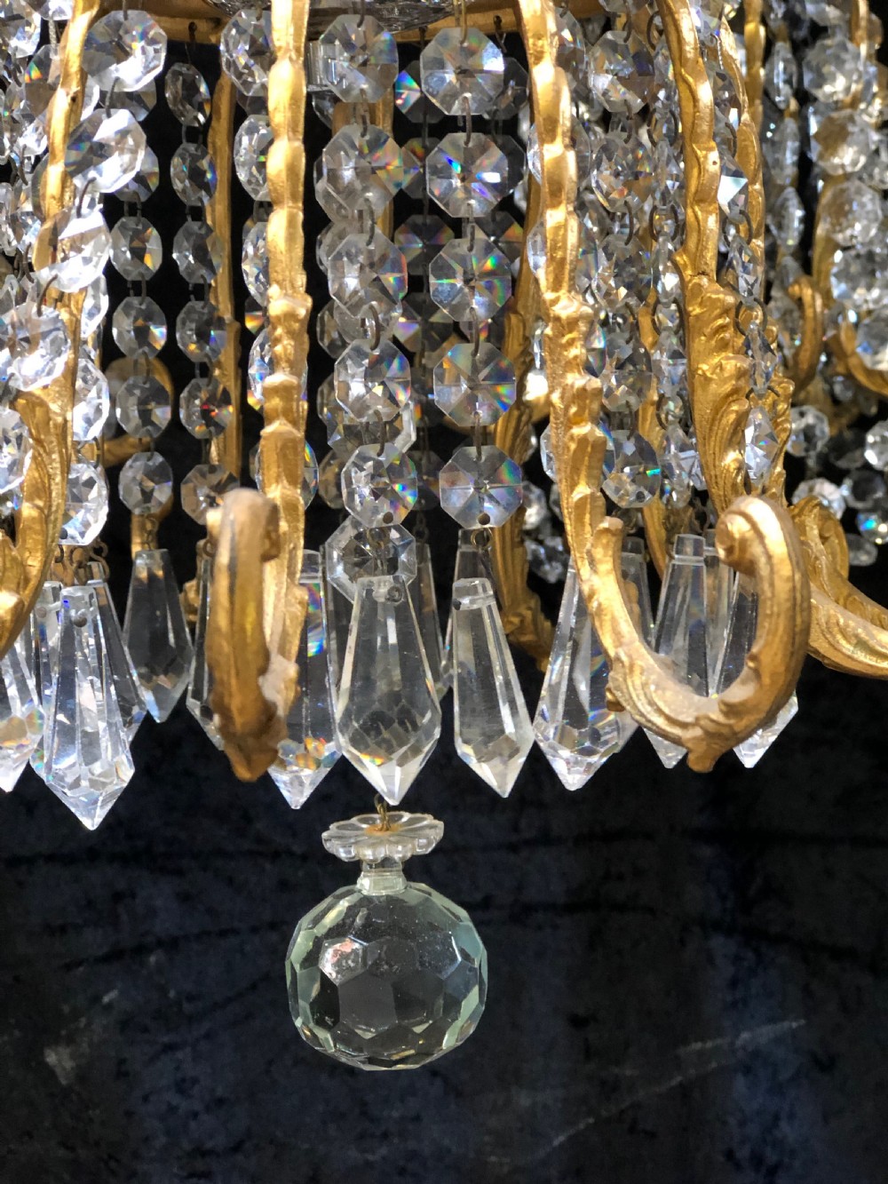 An Italian gilt-brass chandelier featuring multiple scrolling arms draped with crystal-beaded pod shades and amber glass drops. View VI