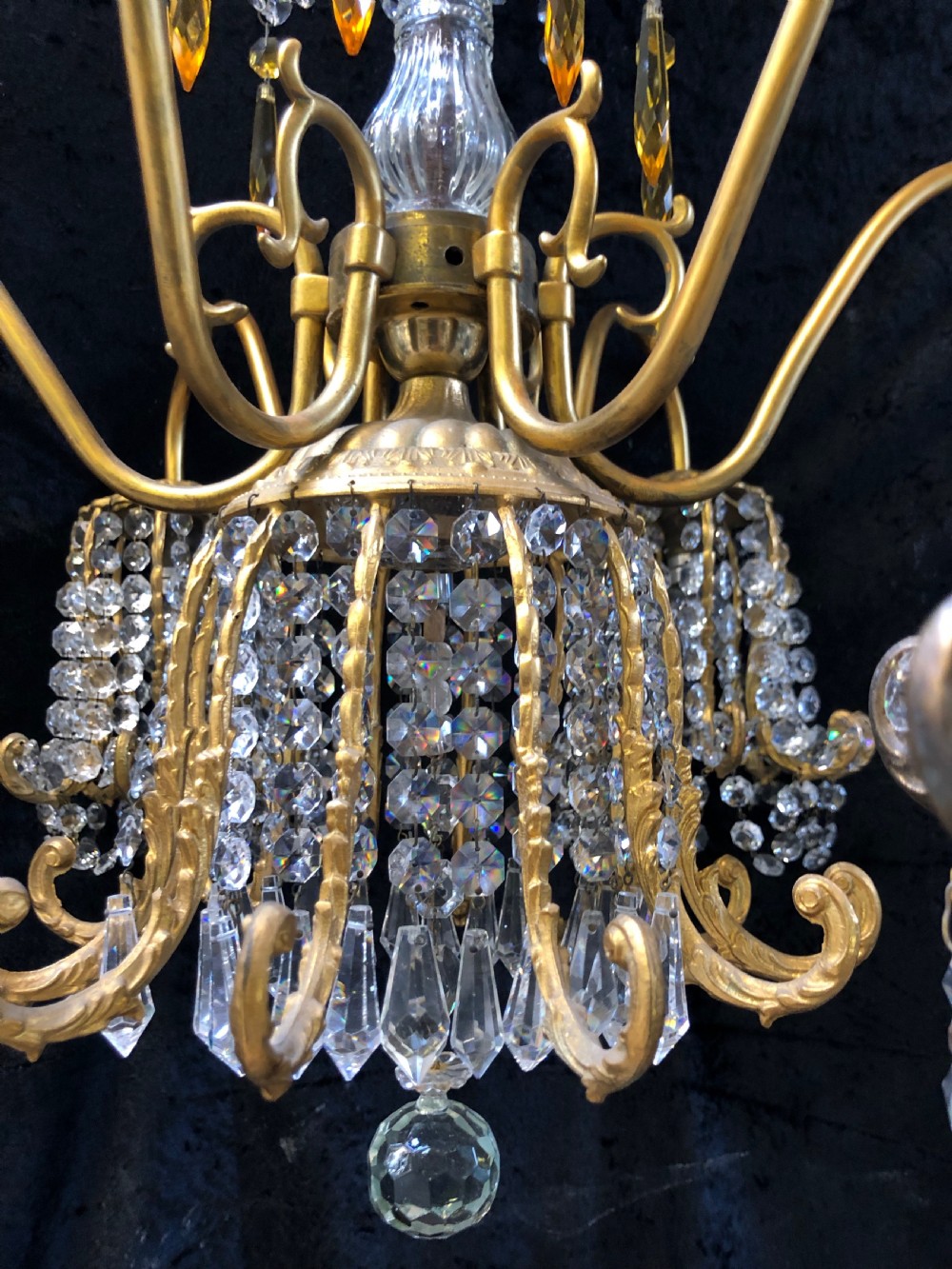 An Italian gilt-brass chandelier featuring multiple scrolling arms draped with crystal-beaded pod shades and amber glass drops. View VII
