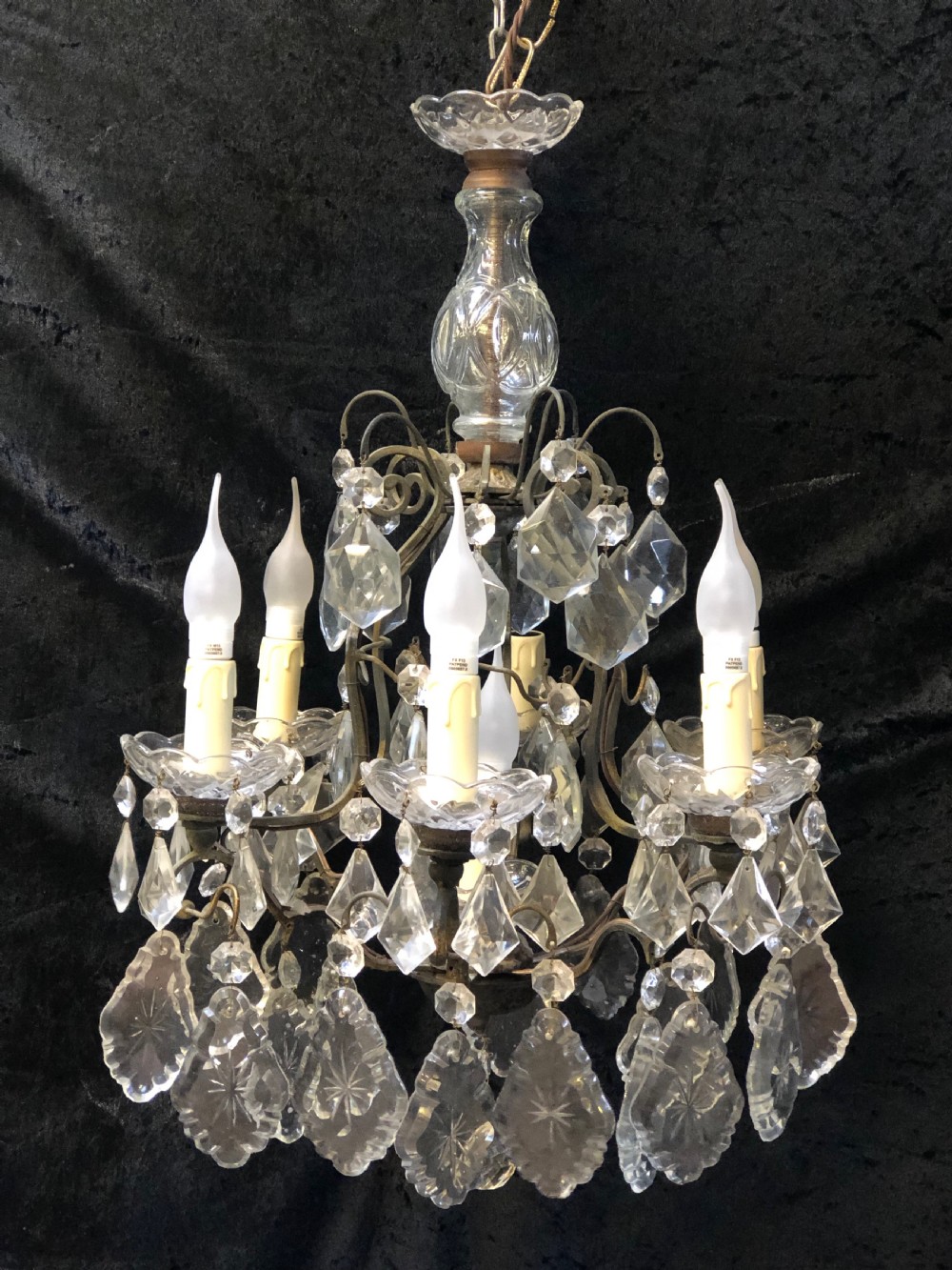 A nine-light French cage-style chandelier featuring a dark patinated metal frame decorated with cut glass crystal drops and a central blown glass stem.