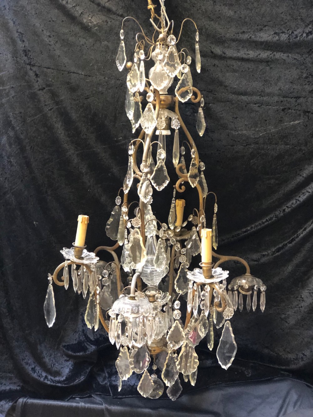 An antique French nine-light chandelier featuring a gilt metal frame dressed with clear faceted cut-glass crystals and pendeloque drops.