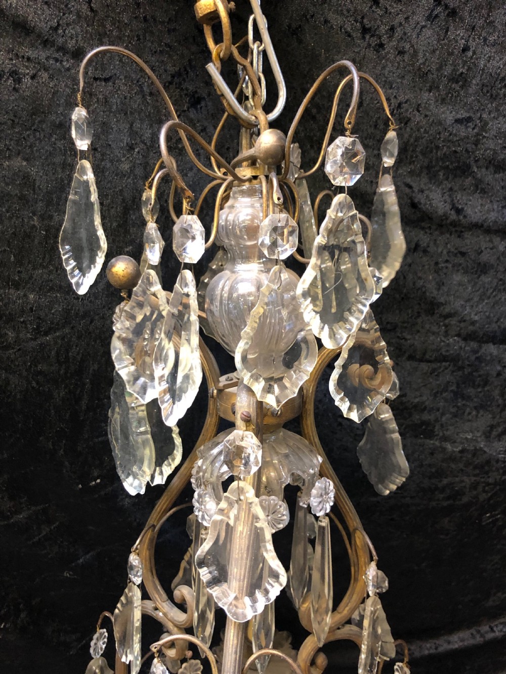 An antique French nine-light chandelier featuring a gilt metal frame dressed with clear faceted cut-glass crystals and pendeloque drops. View II