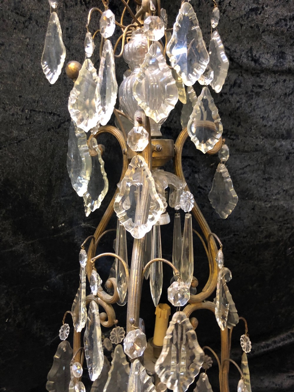 An antique French nine-light chandelier featuring a gilt metal frame dressed with clear faceted cut-glass crystals and pendeloque drops. View III