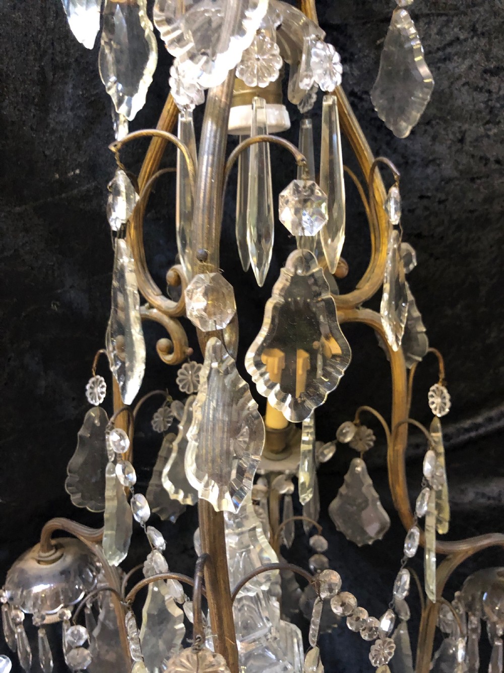 An antique French nine-light chandelier featuring a gilt metal frame dressed with clear faceted cut-glass crystals and pendeloque drops. View VII