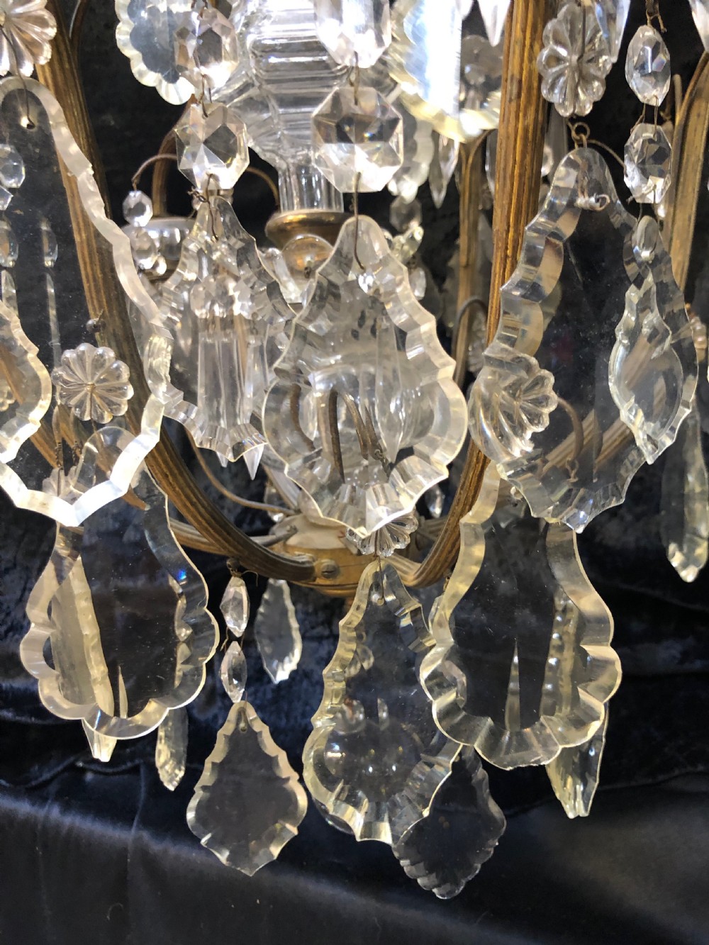 An antique French nine-light chandelier featuring a gilt metal frame dressed with clear faceted cut-glass crystals and pendeloque drops. View XII