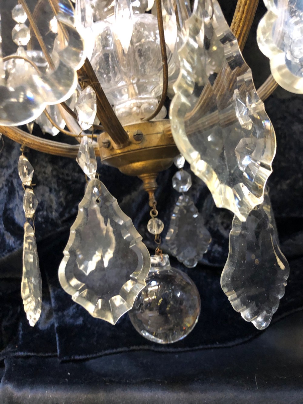 An antique French nine-light chandelier featuring a gilt metal frame dressed with clear faceted cut-glass crystals and pendeloque drops. View XIII