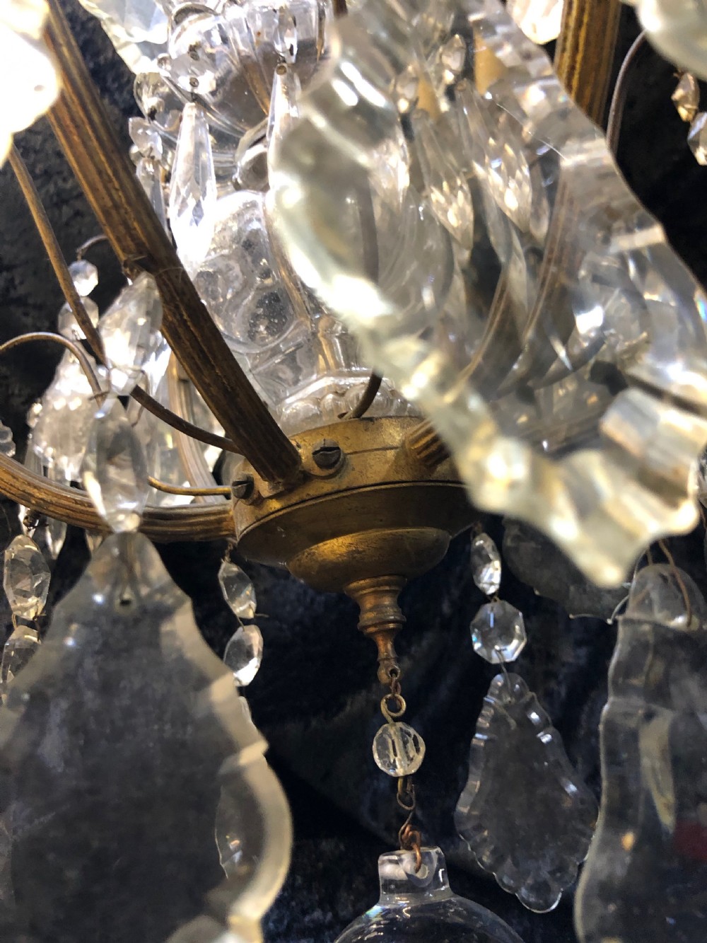 An antique French nine-light chandelier featuring a gilt metal frame dressed with clear faceted cut-glass crystals and pendeloque drops. View XIV
