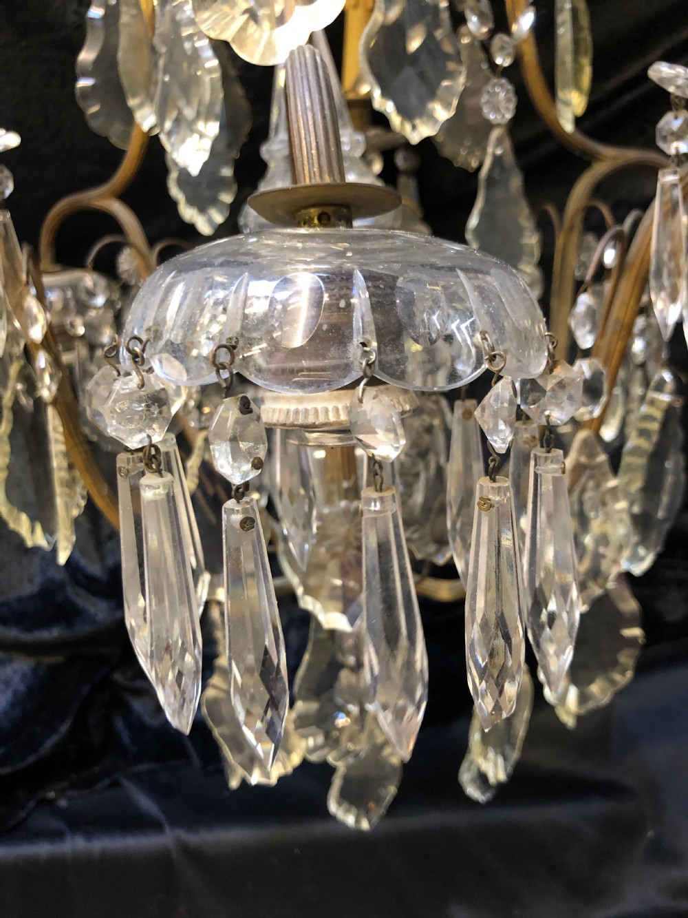 An antique French nine-light chandelier featuring a gilt metal frame dressed with clear faceted cut-glass crystals and pendeloque drops. View XV