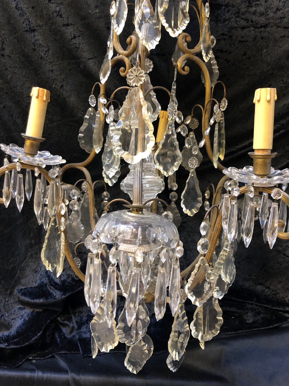 An antique French nine-light chandelier featuring a gilt metal frame dressed with clear faceted cut-glass crystals and pendeloque drops. View XVI