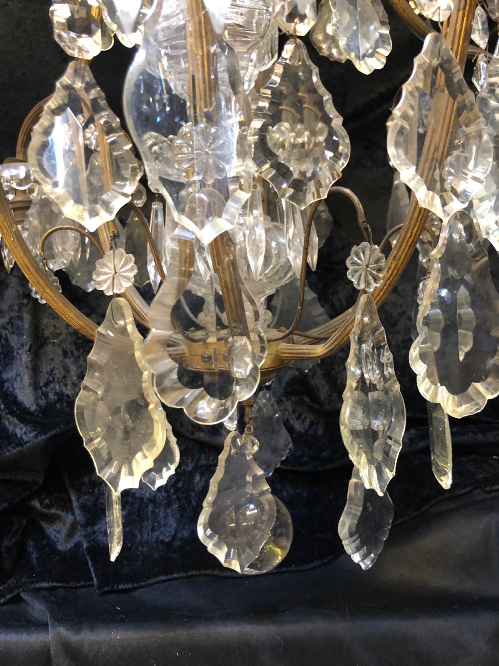An antique French nine-light chandelier featuring a gilt metal frame dressed with clear faceted cut-glass crystals and pendeloque drops. View XVII