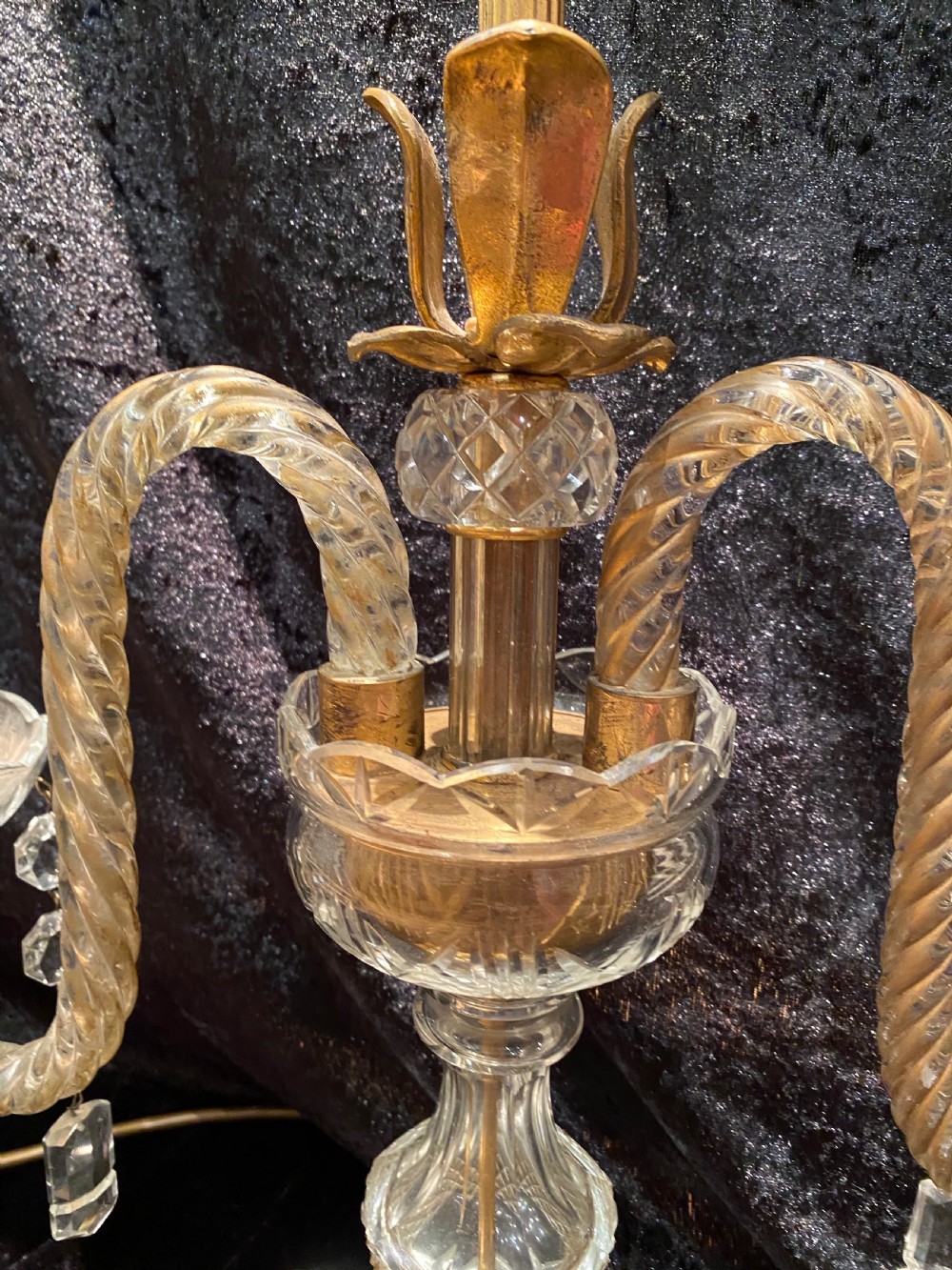 A pair of gilt brass and cut crystal two-arm candelabra table lamps featuring twisted glass arms, cascading crystal droplets, and stepped bases. View VI