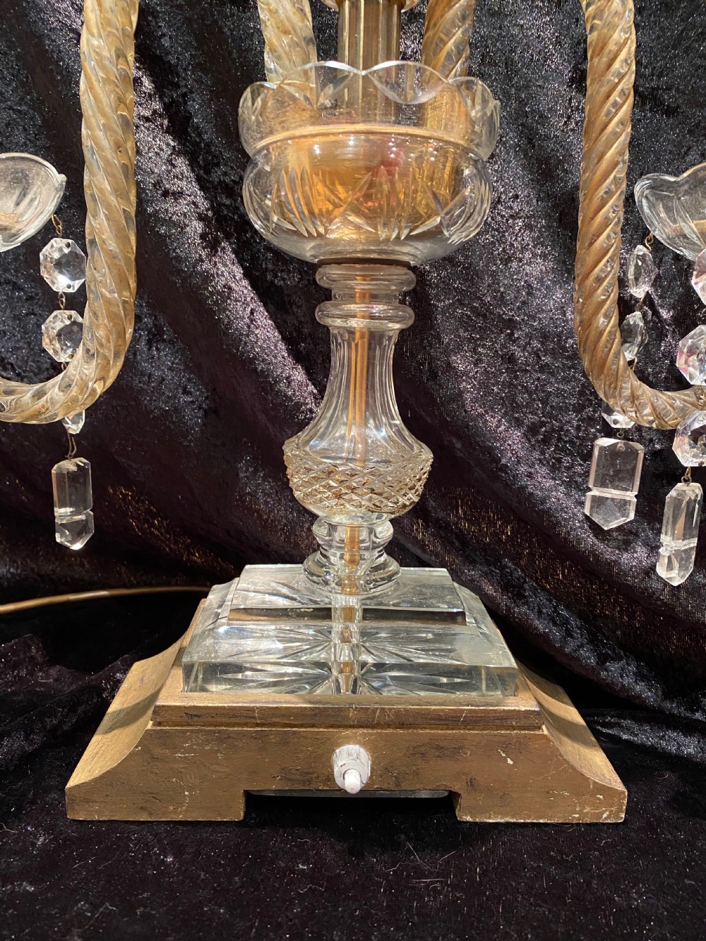 A pair of gilt brass and cut crystal two-arm candelabra table lamps featuring twisted glass arms, cascading crystal droplets, and stepped bases. View IX
