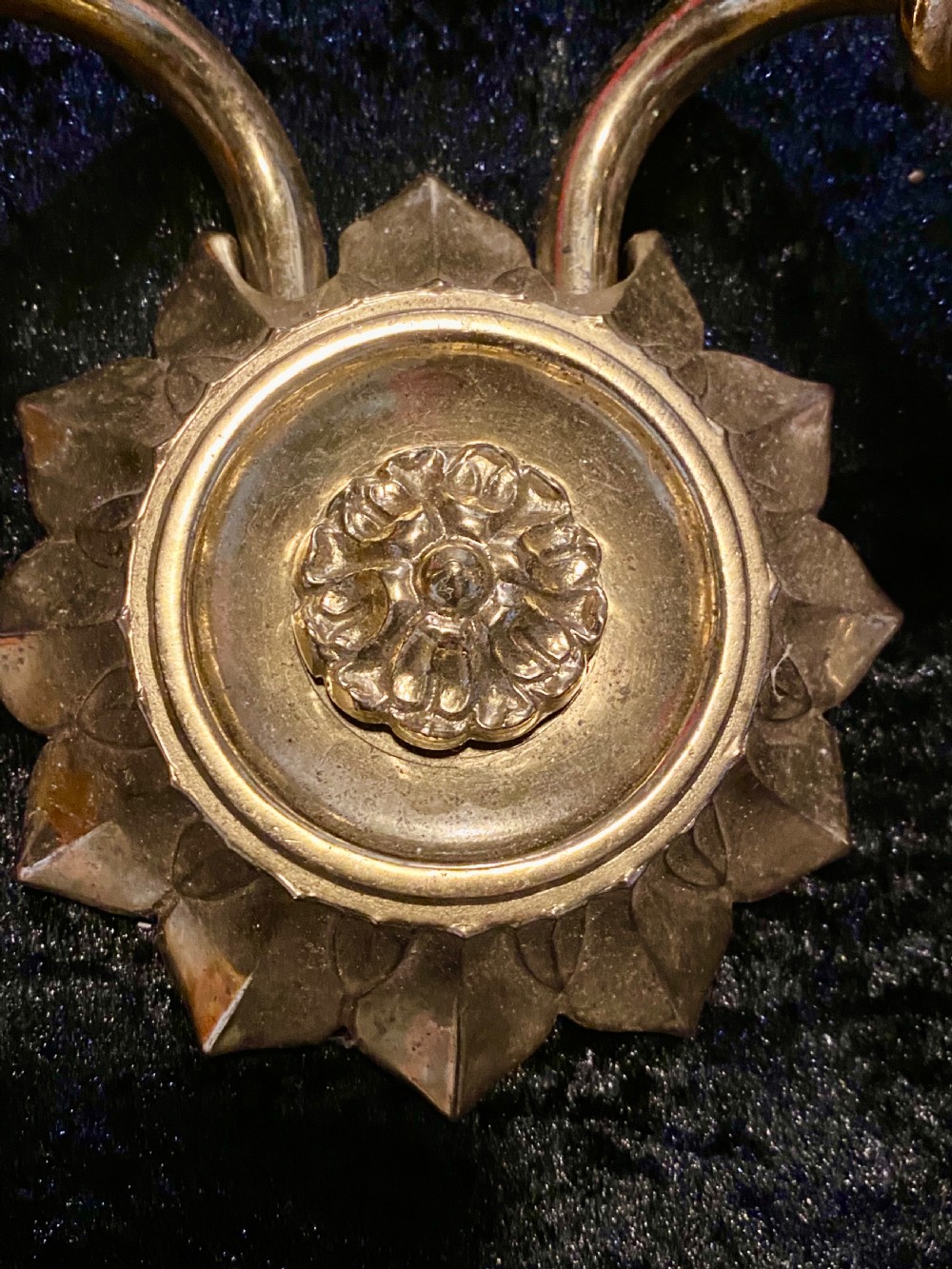 A pair of cast brass two-light wall sconces featuring sunburst backplates and curved acanthus leaf arms. View III