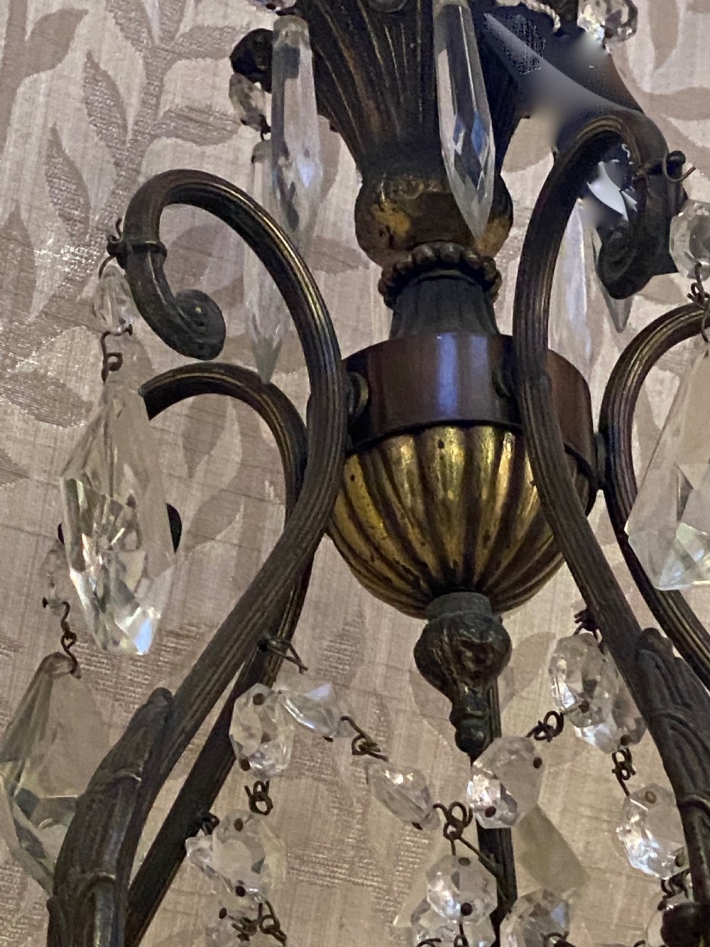 An Italian dark brass five-light chandelier adorned with crystal drops and a central metal cherub figurine. View IV