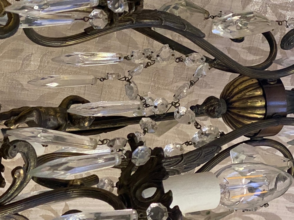 An Italian dark brass five-light chandelier adorned with crystal drops and a central metal cherub figurine. View V