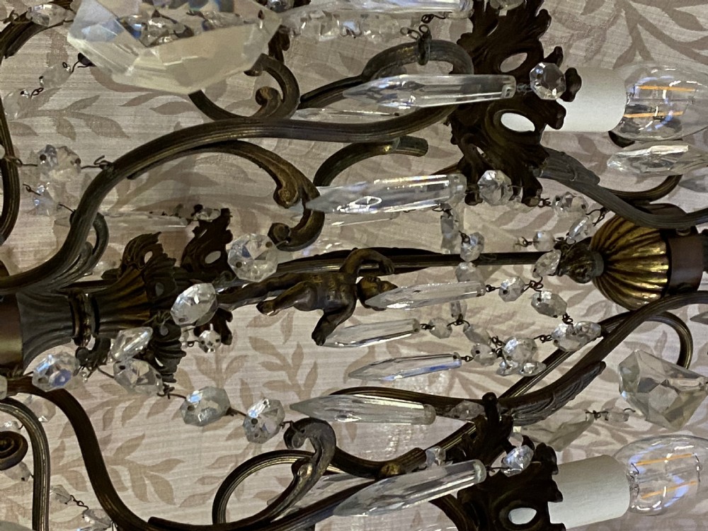 An Italian dark brass five-light chandelier adorned with crystal drops and a central metal cherub figurine. View VII