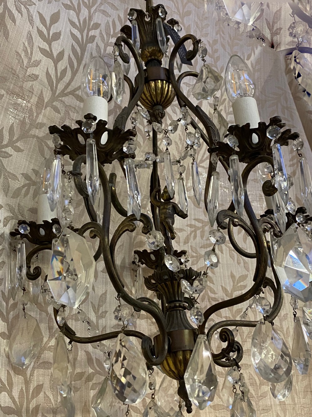 An Italian dark brass five-light chandelier adorned with crystal drops and a central metal cherub figurine. View VIII