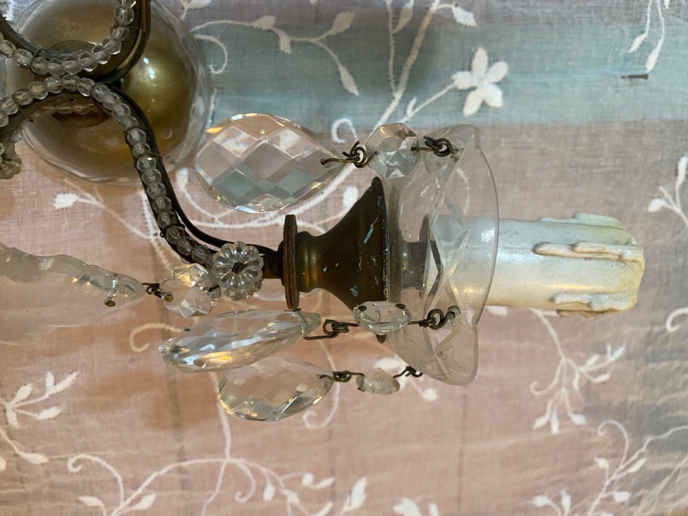 A pair of antique Florentine wall lights featuring twin curved metal arms wrapped in small glass beads, decorated with clear glass droplets, amber crystal prisms, and candle-style lamp holders. View IV