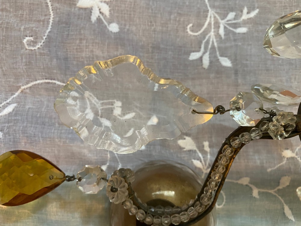 A pair of antique Florentine wall lights featuring twin curved metal arms wrapped in small glass beads, decorated with clear glass droplets, amber crystal prisms, and candle-style lamp holders. View V