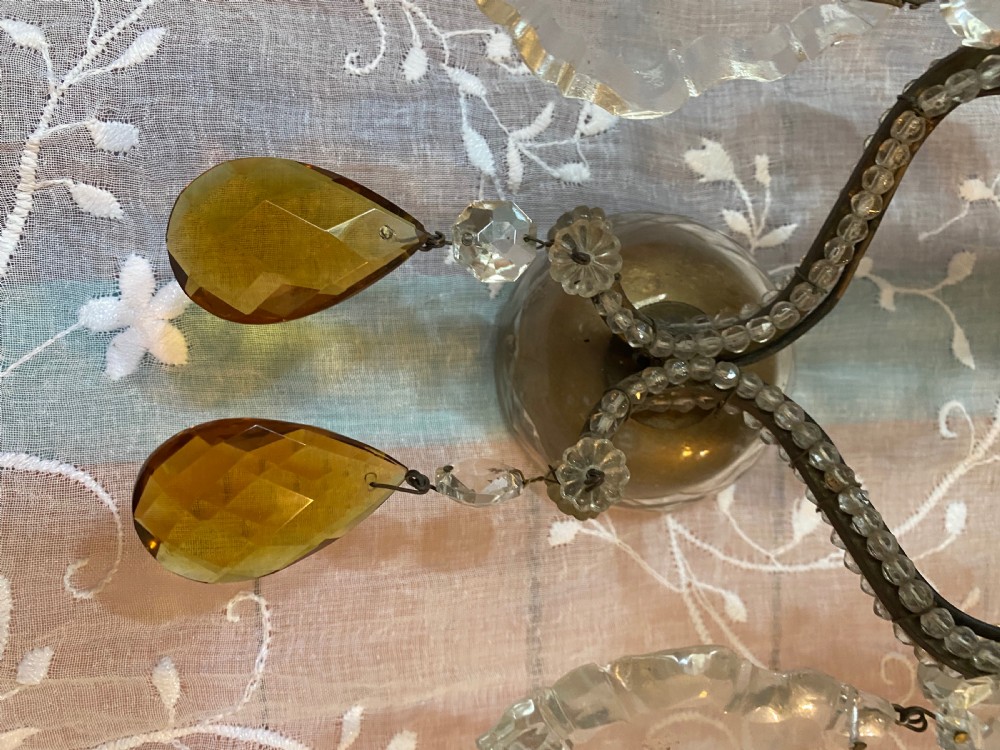 A pair of antique Florentine wall lights featuring twin curved metal arms wrapped in small glass beads, decorated with clear glass droplets, amber crystal prisms, and candle-style lamp holders. View VI