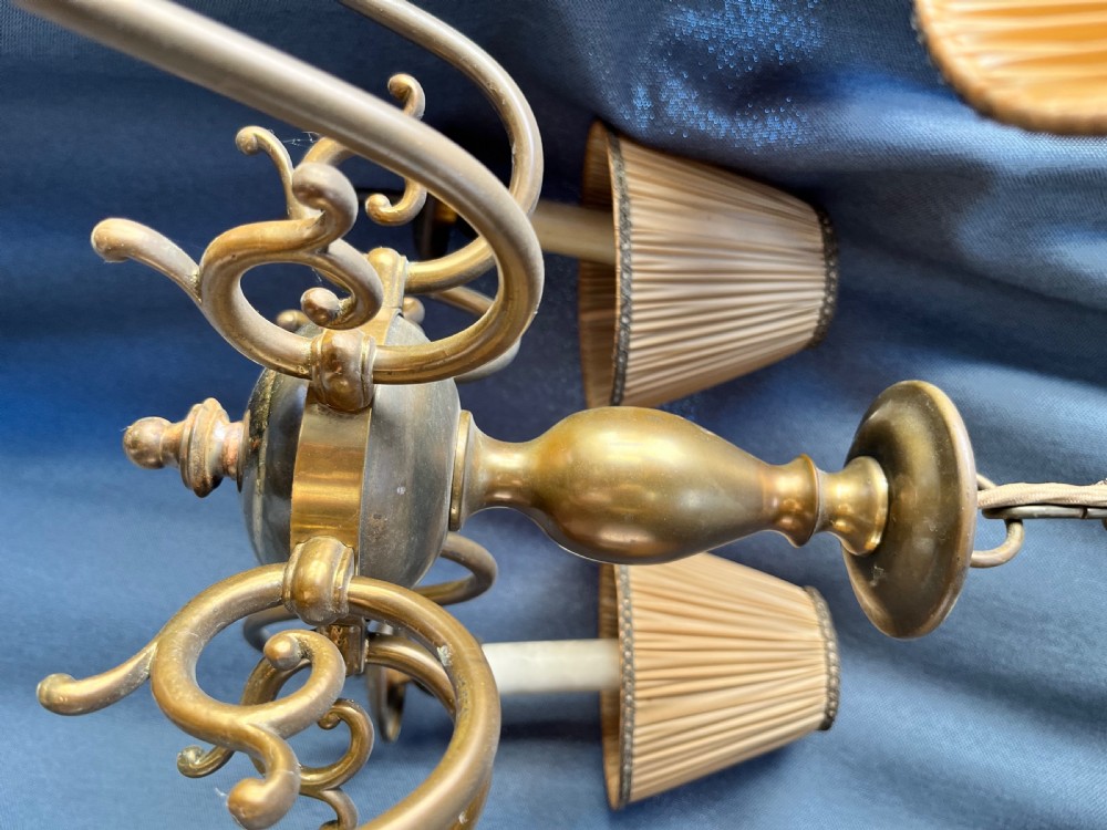 A six-arm brass Dutch pendant chandelier featuring a turned central baluster stem, scrolled arms, drip pans, and candle sleeves. View III