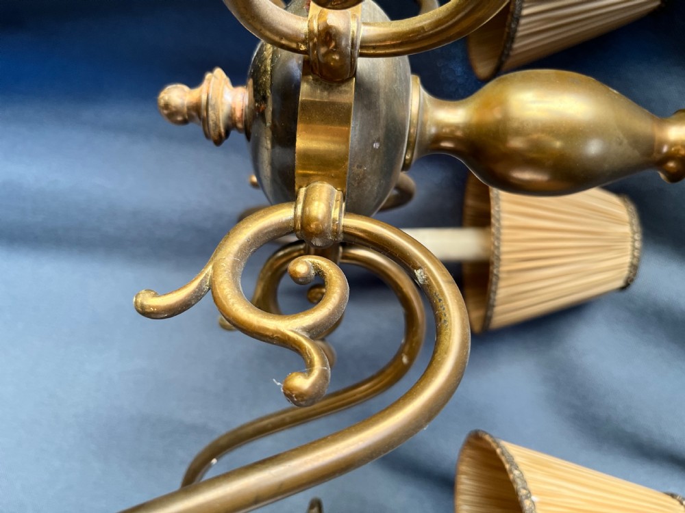 A six-arm brass Dutch pendant chandelier featuring a turned central baluster stem, scrolled arms, drip pans, and candle sleeves. View IV