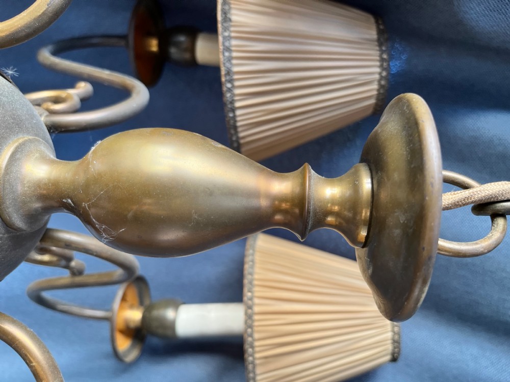 A six-arm brass Dutch pendant chandelier featuring a turned central baluster stem, scrolled arms, drip pans, and candle sleeves. View V