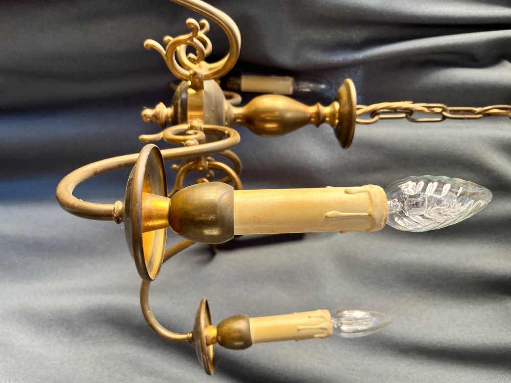 A six-arm brass Dutch pendant chandelier featuring a turned central baluster stem, scrolled arms, drip pans, and candle sleeves. View VII