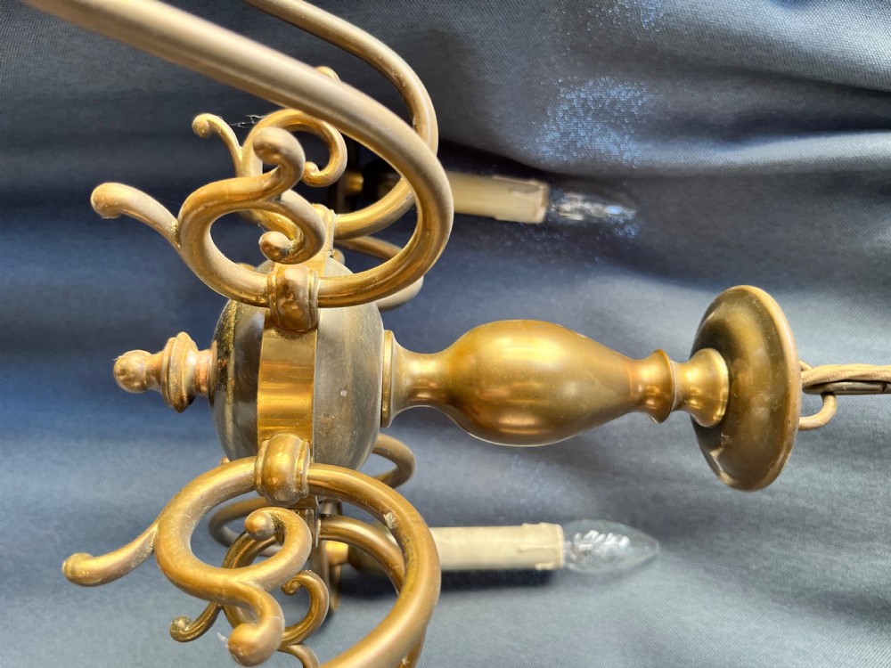 A six-arm brass Dutch pendant chandelier featuring a turned central baluster stem, scrolled arms, drip pans, and candle sleeves. View IX