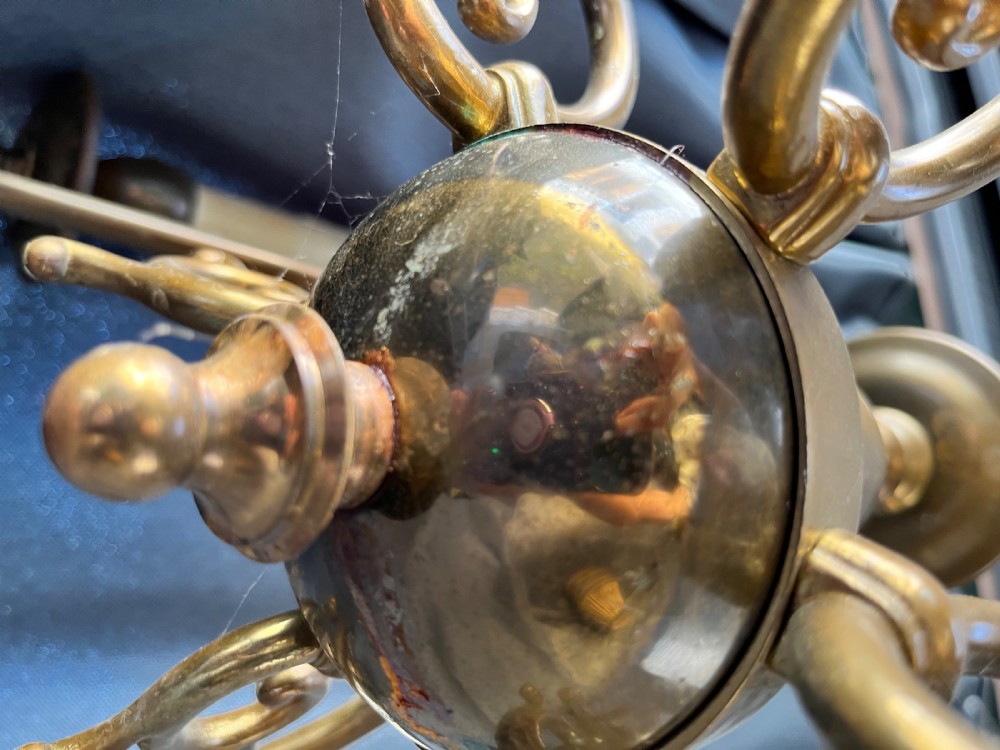 A six-arm brass Dutch pendant chandelier featuring a turned central baluster stem, scrolled arms, drip pans, and candle sleeves. View XI