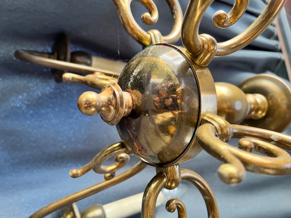 A six-arm brass Dutch pendant chandelier featuring a turned central baluster stem, scrolled arms, drip pans, and candle sleeves. View XII