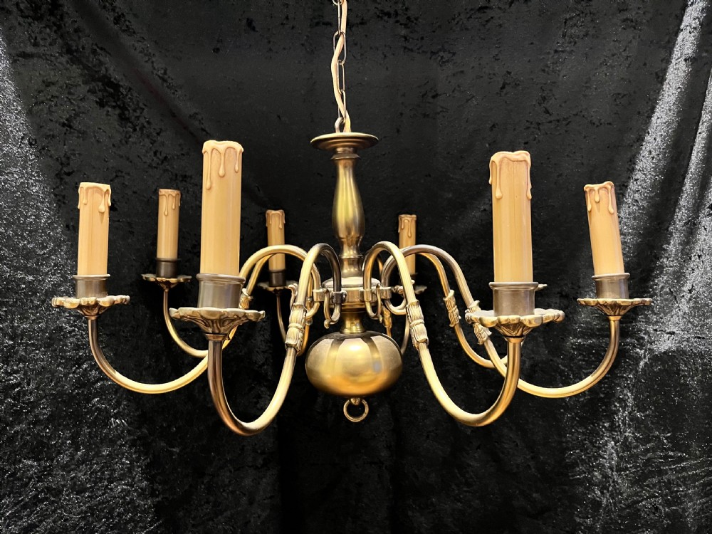 A 1920s Dutch brass eight-light chandelier featuring curved S-scroll arms with faux candle sleeves around a central turned baluster stem. View II