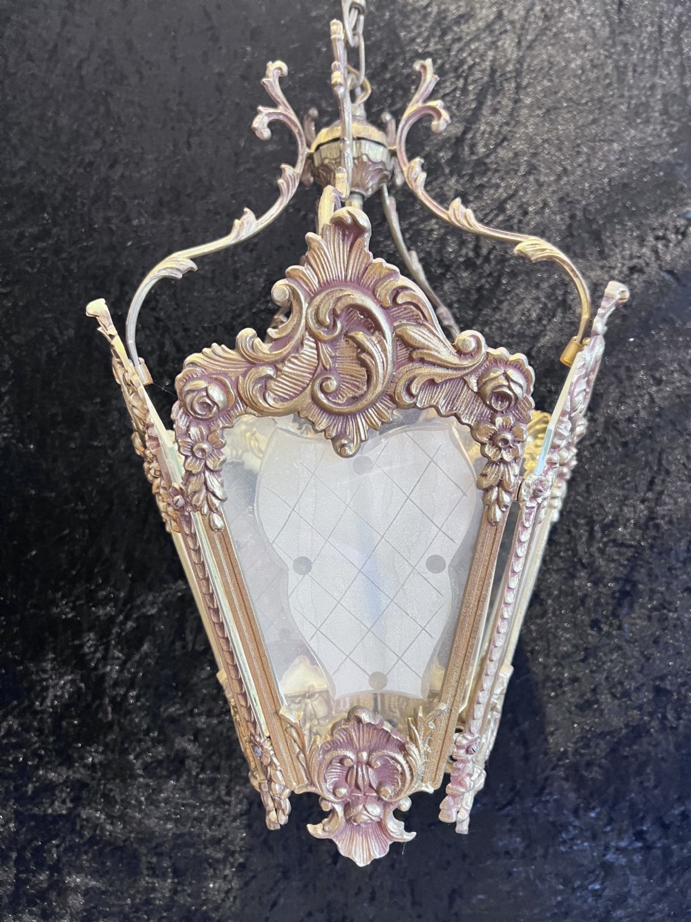 An ornate French Rococo brass hanging lantern featuring etched frosted glass panels and intricate floral metal scrollwork.