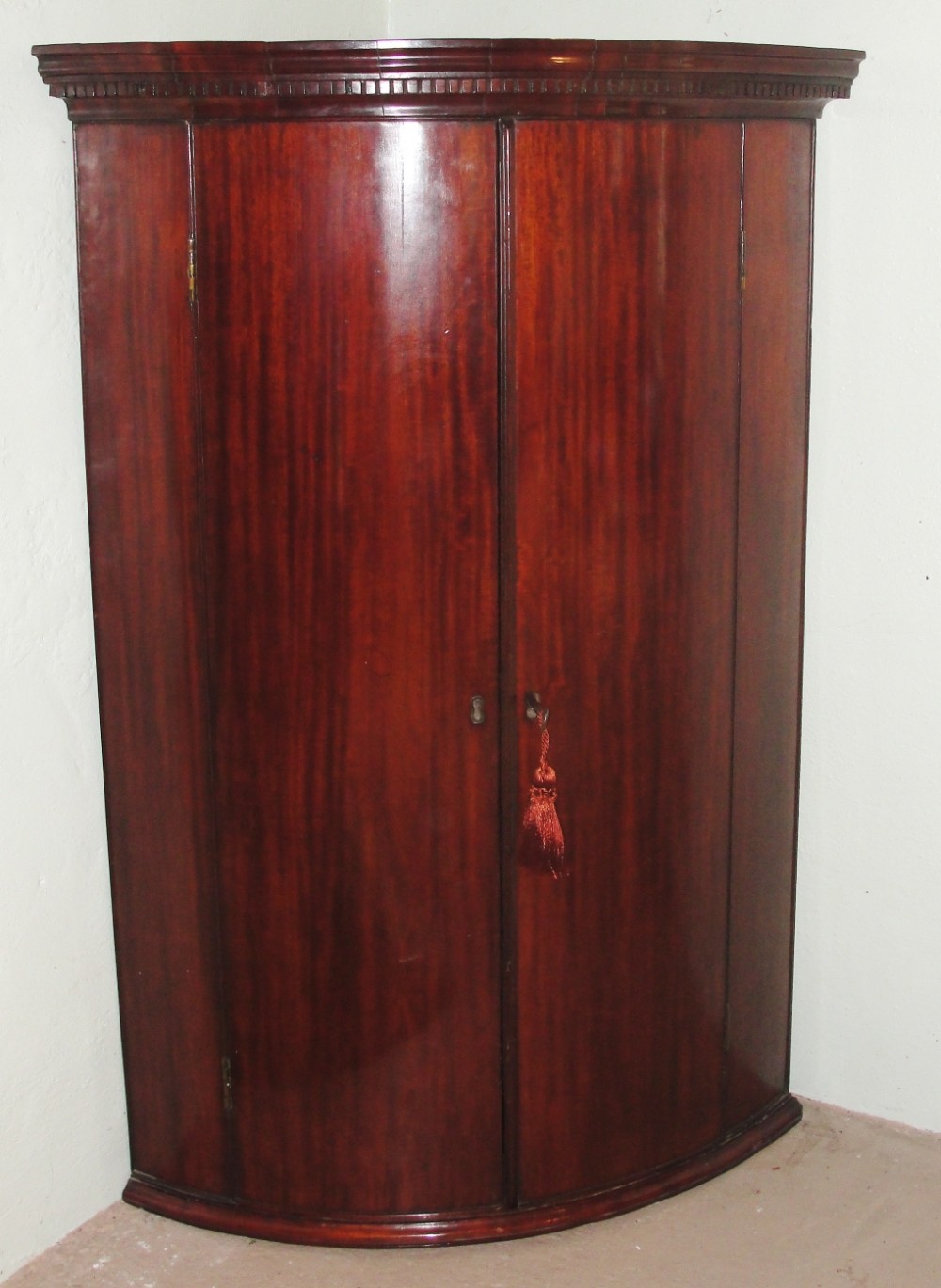 Georgian mahogany bow fronted hanging corner cabinet. Circa 1760