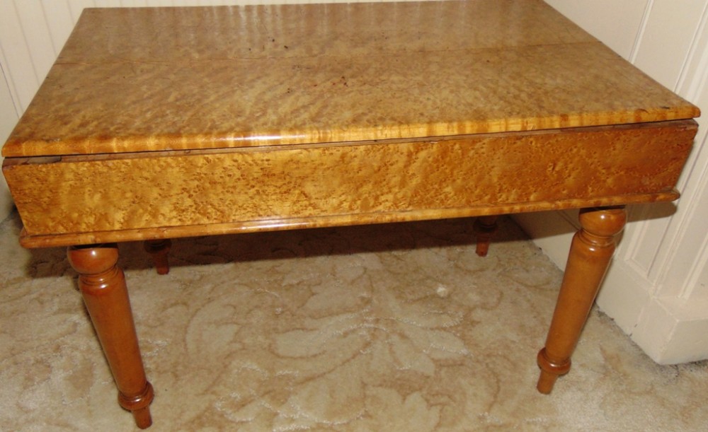 A rectangular Victorian birdseye maple low coffee table with turned legs and a flat top enclosed lid structure.