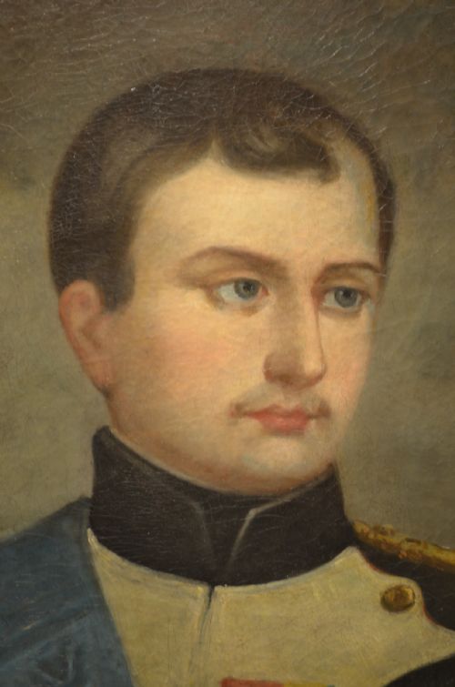 fig 2. An oval oil painting depicting Napoleon Bonaparte in a dark military uniform with gold epaulettes and a light blue sash, set within a gilt wood frame.
