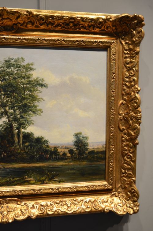 fig 3. A pair of 19th-century oil paintings on canvas depicting peaceful English rural landscapes framed in elaborate gold giltwood frames.